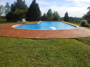 Leandro N. AlemPortal de Alem Hotel的庭院里的游泳池,草地上设有长凳