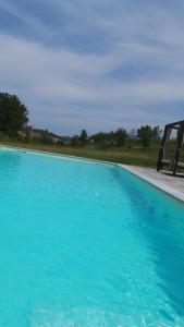 蒙特格罗索达斯提Sotto La Vigna Charm Stay Adults only vacation Appartement Hayloft的一片大片的蓝色水,靠近一片田野