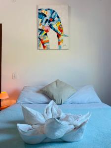 阿拉亚尔-杜卡布Pousada Arraial Caribe的床上的毛巾,墙上有绘画作品