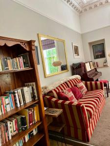 格拉斯哥Beautiful Double Room in Idyllic West End Townhouse的客厅配有沙发和书架,书架上装满了书籍