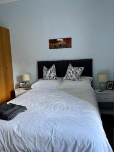 格拉斯哥Beautiful Double Room in Idyllic West End Townhouse的一间卧室配有一张带两盏灯的大型白色床。