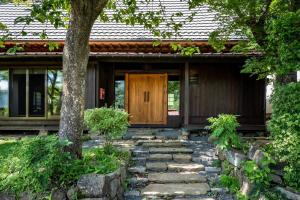 山梨市LiveGRACE House Lake Saiko 西湖古民家的一座房子,设有通往木门的石道