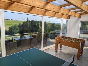 许特根瓦尔德Eifel-Ferienhaus Landblick的庭院里设有乒乓球桌的房间
