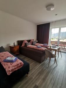 OberortHaus Bergblick的客房设有两张床、一张沙发和一张桌子。