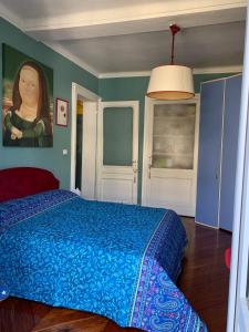 都灵Maria Vittoria House的卧室配有一张蓝色的床,墙上挂着一幅画
