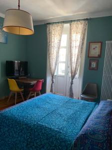 都灵Maria Vittoria House的一间卧室配有一张蓝色的床和桌椅