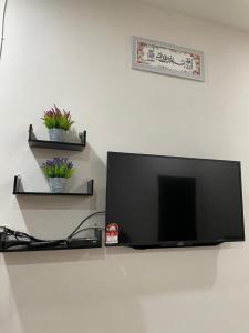 加央HOMESTAY BANDAR KANGAR (NS FAMILY HOMESTAY)的壁挂上方的平面电视