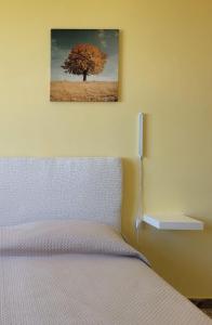 泰尔莫利Pepe rosa的卧室配有一张床铺,墙上挂着一棵树