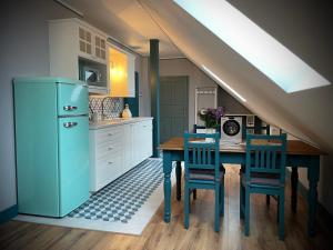 捷克克鲁姆洛夫TGM Apartments的厨房配有桌子和蓝色冰箱。