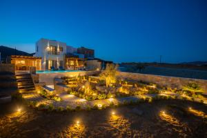 帕诺尔莫斯米科诺斯Summer Breeze Luxury Villa Mykonos的享有庭院的景色,晚上有灯光