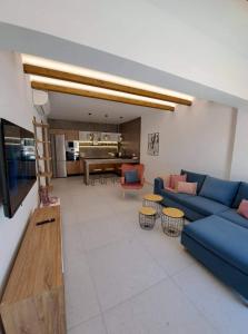 佩基罗德Courtyard Luxury Suites “MARIANTHI”的客厅配有蓝色的沙发和桌子