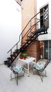 玛德琳港艾尔瑞拓诺旅舍的一个带桌子和两把椅子的庭院和一个楼梯