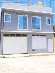 圣克鲁斯华特库Departamento Anel en Huatulco的街上有两扇车库门的房子