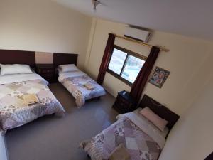 瓦迪穆萨佩特拉门大酒店 的客房设有两张床、镜子和窗户。