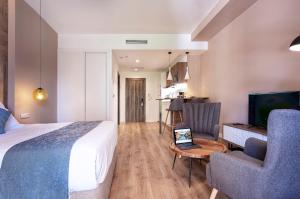 索里亚Dauria Suites HA的酒店客房配有一张床和一张带笔记本电脑的桌子