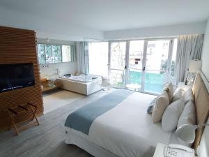 布宜诺斯艾利斯卡萨卡尔玛酒店的一间大卧室,配有一张大床和一个浴缸