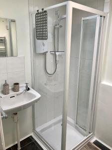 温德米尔布里斯科自助式公寓酒店的带淋浴和盥洗盆的白色浴室