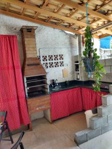 塞尔苏拉穆斯州长镇CASA DA ANA E ZÉ的厨房配有水槽和红色桌子
