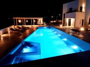 莫诺利索斯myLithos Suites的游泳池在晚上点亮