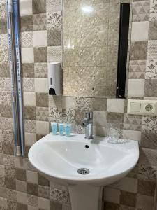 谢赫维蒂利Villa Story Hotel的浴室设有白色水槽和镜子
