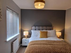 诺里奇Norwich, Lavender House, 3 Bedroom House, Private Parking and Garden的一间卧室配有一张大床和两盏灯。