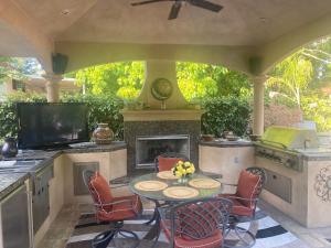 Cameron ParkTuscany Dorado Resort的庭院配有桌椅和壁炉。