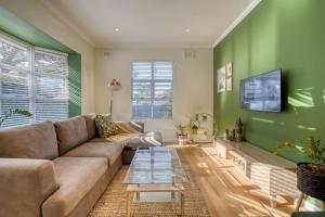 德班Hampton Collection - Stylish 3 Sleeper Apartment with Pool的客厅设有棕色沙发和绿色墙壁。