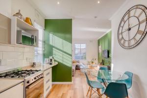德班Hampton Collection - Stylish 3 Sleeper Apartment with Pool的厨房设有玻璃桌和绿色墙壁