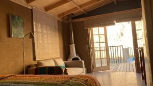 Monte GrandeCasa Almendro的客厅设有床和滑动玻璃门