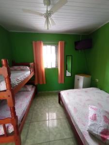 大普拉亚Pousada/suites Praia Grande III的一间卧室设有两张双层床和绿色的墙壁