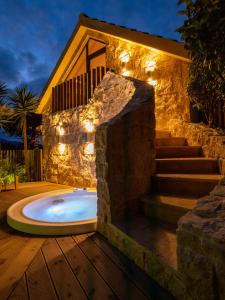 圣维森特费雷拉Azor Eco Lodge的一个带按摩浴缸的庭院,与房子相连