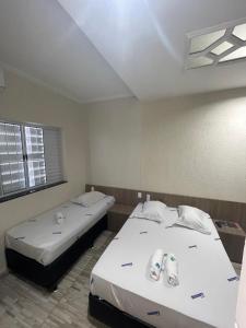 圣保罗Hotel Aricanduva的客房设有两张床和窗户。