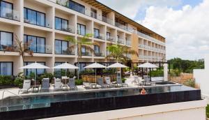 坎昆Hive Cancun by G Hotels的一个带游泳池、椅子和遮阳伞的酒店