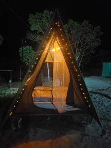 帕拉蒂Terras de Maria Bonita的帐篷内的一张床位,周围设有灯光