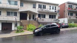 蒙特利尔Montreal Downtown Suite的停在房子前面的一辆黑色汽车