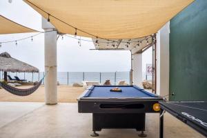 Primo TapiaTriton's Playhouse Beachfront的一间带台球桌和吊床的客房以及海滩