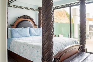 Primo TapiaTriton's Playhouse Beachfront的一间卧室配有一张带蓝色枕头的天蓬床