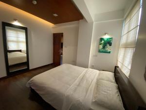 马累Luxury 3 Room Apartment by Oboe的卧室配有白色的床和镜子