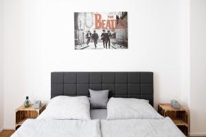 萨勒河畔哈雷Ko-Living - Beatles und Banksy Suites & Studios am Eselsbrunnen - Altstadt - Küche的卧室配有一张壁挂式海报的床