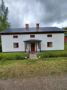 瓦尔德马什维克Kopparhyttan1的一间设有红色门的大型白色房屋