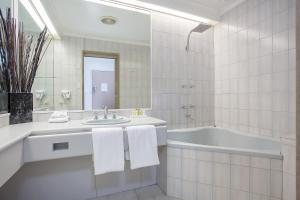 沃纳姆堡瓦南布尔中城汽车旅馆的白色的浴室设有浴缸和水槽。