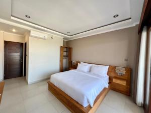 坎古Sandat Living的一间卧室配有一张带白色床单的大床