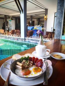 班泰Billabong Hotel and Cafe的游泳池旁的早餐盘鸡蛋和面包