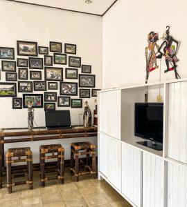 玛琅Hostel Wees een Kind的客厅配有电视和图片墙