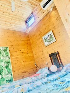镰仓市ハセノ島　Hotel　Cottage的卧室配有木墙内的一张床