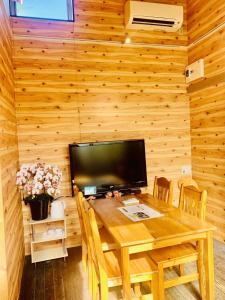 镰仓市ハセノ島　Hotel　Cottage的木餐厅,配有桌子和电视