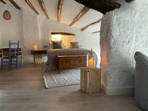ArdenyaCasa rural con jardín,a 8km playa y en la naturaleza Taronja&canyella的一间卧室配有一张床和一张带两个蜡烛的桌子。