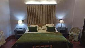 AmpudiaHotel Casa del Abad的一间卧室配有一张大床和两盏灯