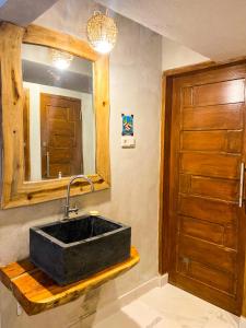 玛琅Hostel Wees een Kind的浴室设有黑色水槽和镜子