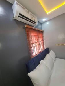 阿布贾Wine House, Maitama, Abuja的一间设有蓝色沙发、加热器和窗户的客房